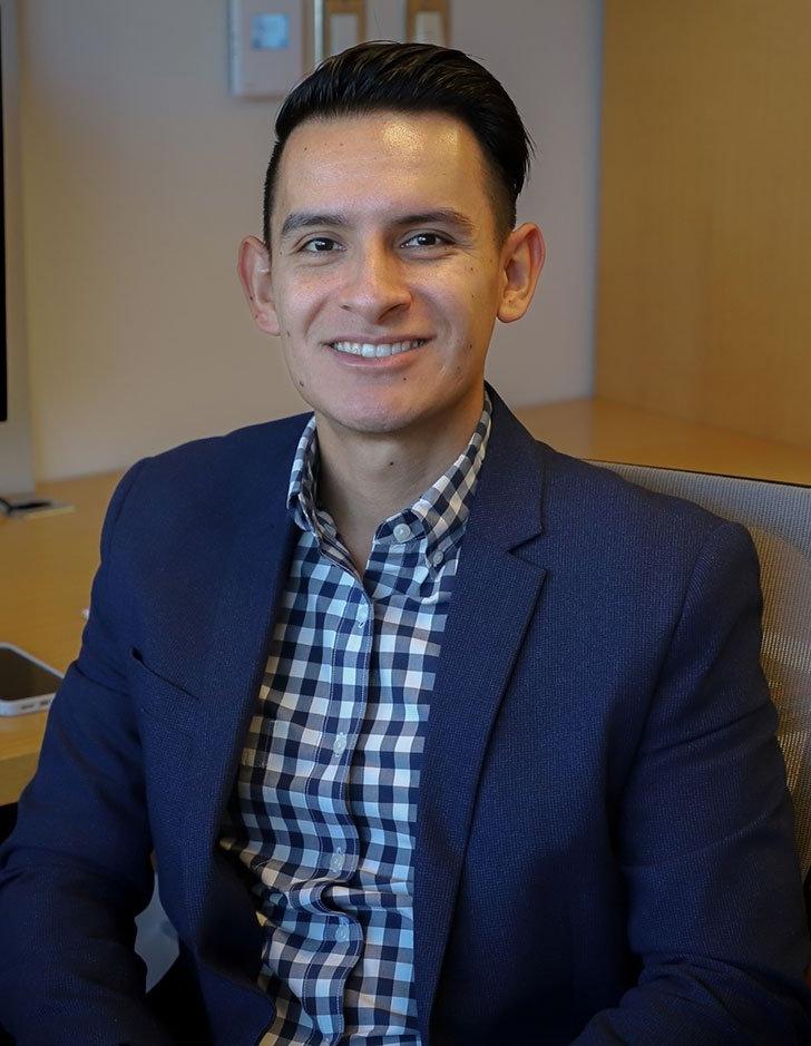 portrait of cesar vargas nunex sitting at a desk in a office